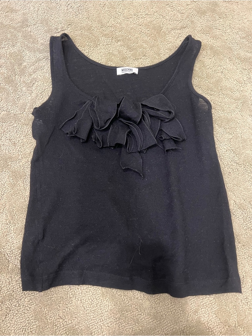 Moschino black chic black sleeveless top with the large ruffle/flower detail.